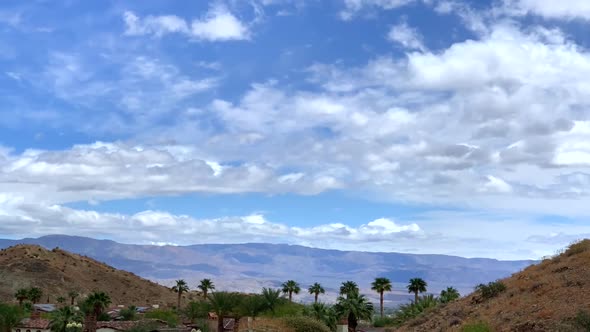 4k Time-lapse of desert mountain with clouds and palm trees with blue skies. Palm Springs, Californi