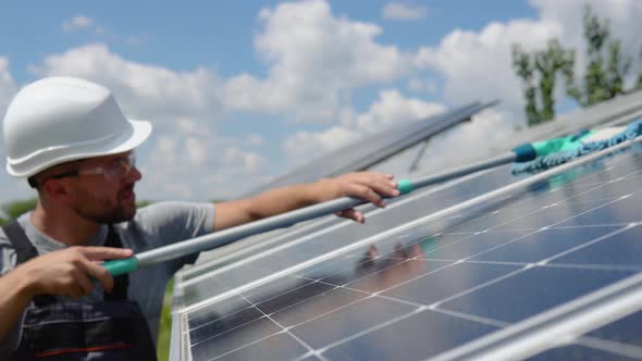 Worker Cleans Solar Panel with Water Clean at Solar Power Plant