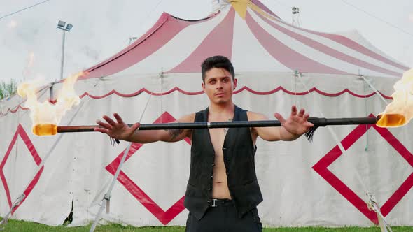 Circus artist holding burning contact fire staff