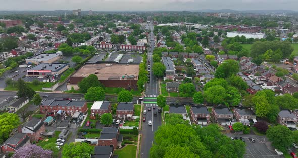 High aerial descending shot of American city. Wet, rainy, overcast day in spring. Houses, schools, c