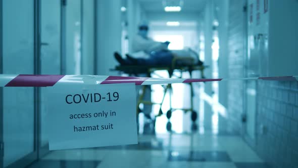 Coronavirus Pandemic Concept. Clinic Worker in Hazmat Treats Patient in Restricted Zone.