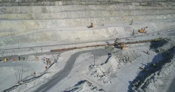 Aerial View Excavator Loads Freight Train Wagons with Rock