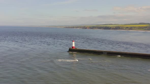 A Lighthouse and Breakwater at the Mouth of a Harbour in the UK