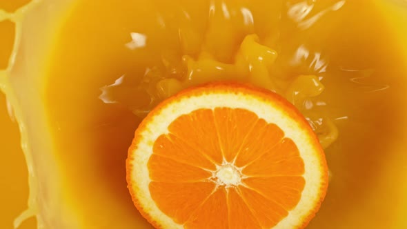 Super Slow Motion Shot of Orange Slice Splashing to Orange Juice at 1000Fps