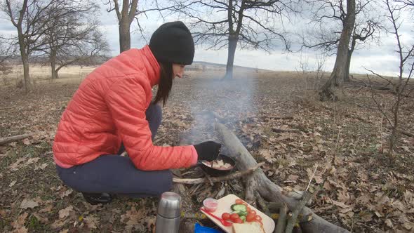 Girl Having Rest with Hot Drink, Tea From Thermos Sitting on the Tree in the Forest