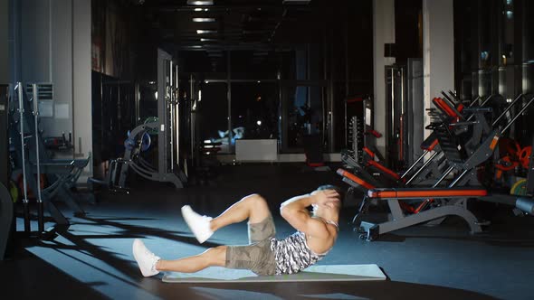 Sport Male Athlete Exercising Doing Abs Crunches Workout Cardio Fitness Routine on Floor Mat in Gym