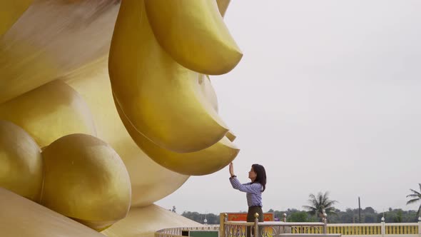 Asian woman Pay respect at the finger of Giant Golden Buddha in Wat Muang in Ang Thong