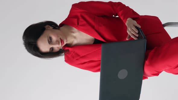Vertical video of 35s nice-looking attractive gorgeous charming cheerful woman using laptop computer