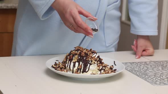 A Woman Prepares A Count's Ruins Cake From Meringue, Cream And Chocolate. Decorate The Cake With Cho