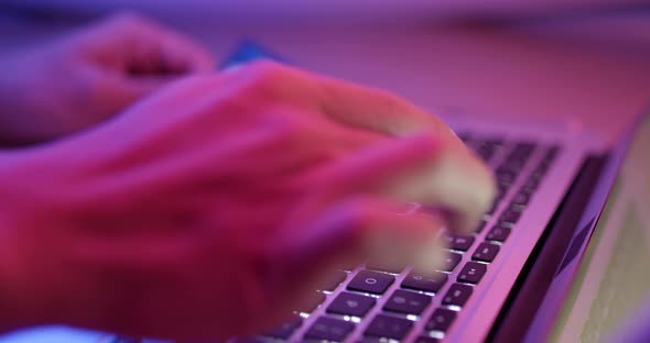 Typing on notebook computer with red and blue light