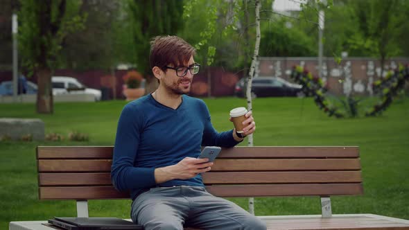 Handsome young man browsing smartphone social network