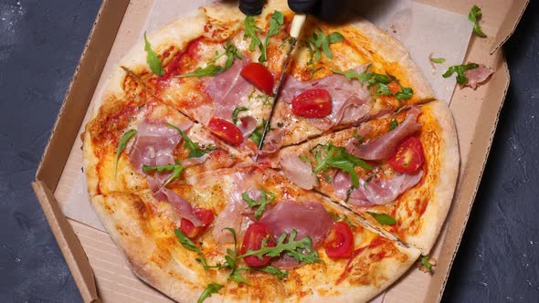 Cutting Pizza with a Knife in Gloves Top View