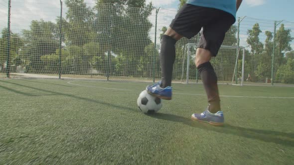 Closeup Front View of Soccer Player Legs in Football Boots with Ball