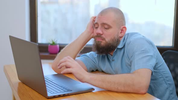 Tired Elder Man Employee Sitting at Working Place at Home Office