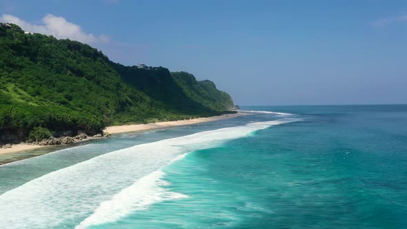 tropical turquoise blue ocean waves along mountain coastline beach of Nyang Nyang in Uluwatu Bali on