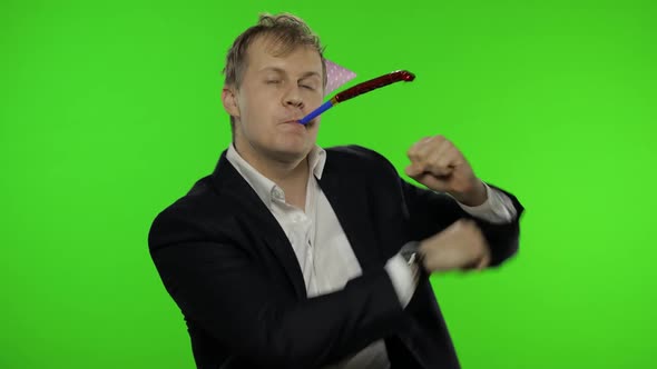 Drunk Disheveled Young Businessman in Festive Cap Celebrates and Dances