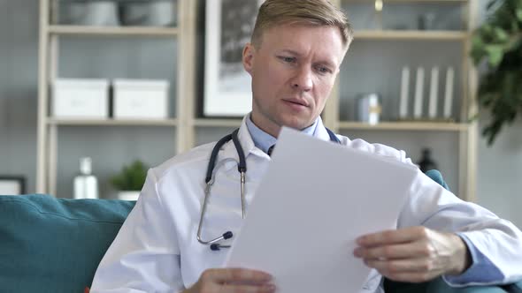 Doctor Reading Medical Report of Patiet Paper Work