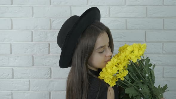 Beautiful girl in a black hat with yellow flowers.