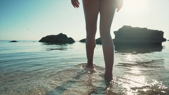 Unrecognizable Woman Walking Into Sea Water. Girl with Slim Sexy Body on Tropical Vacation, Sand