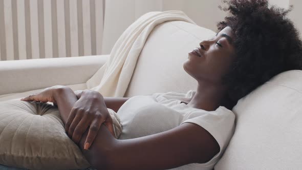 Close Up of Mixed Race Young Woman Relax Leaned on Comfy Couch in Light Warm Cozy Living Room Alone