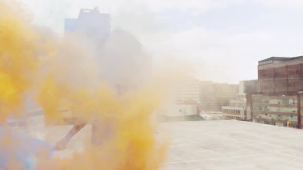 Fashionable young woman on urban rooftop using smoke grenades