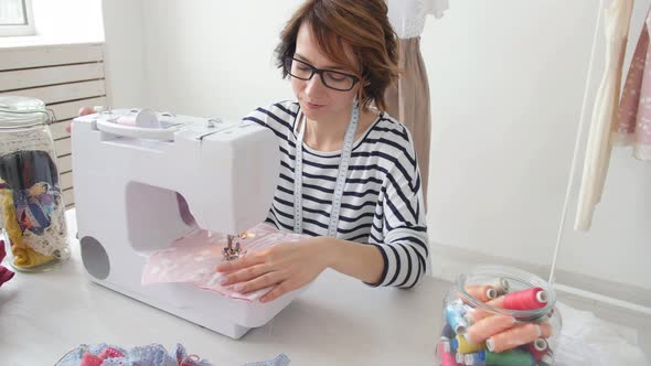 Young Dressmaker Woman Sews Clothes