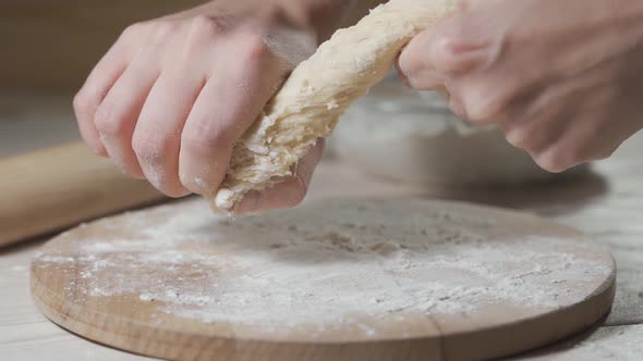Sprinkled Flour Drops Onto Dough Being Rolled with Rolling Pin, in Soft Focus, in Soft Light, in