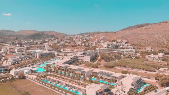 Drone flying over beautiful hotel with mountains.