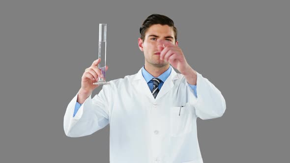 Doctor using digital screen while examining chemical in test tube