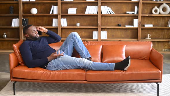 AfricanAmerican Man Has Phone Conversation Lying on the Couch