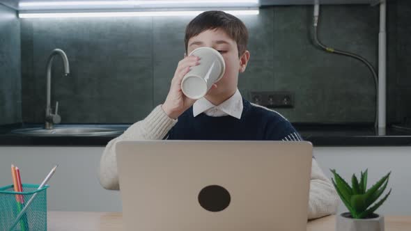 1213 Years Old Schoolboy Using Laptop Computer for Online Education at Home