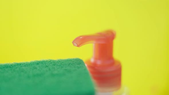 Kitchen Sponges and a Plastic Bottle with Natural Dishwashing Liquid Soap in Use for Hand