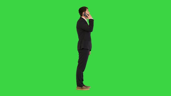 Asian Man in Office Suit Talking on Mobile Phone on a Green Screen Chroma Key