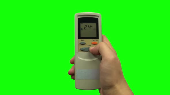 Hand Pushing Temperature Button on Air Conditioner Remote Control. Green Screen