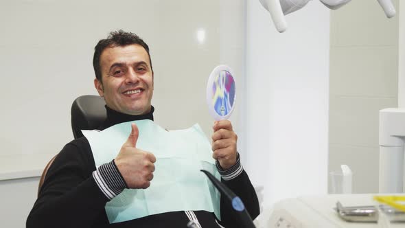 Happy Mature Man Showing Thumbs Up After Dental Examination