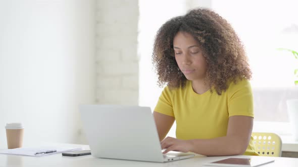 African Woman with Laptop Shaking Head in Approval