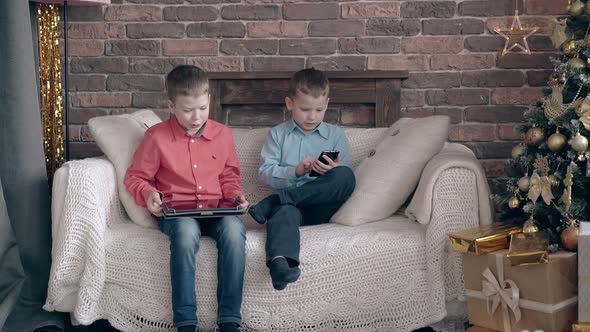 Schoolkids Sit on Sofa Share Impressions About Tablet Games