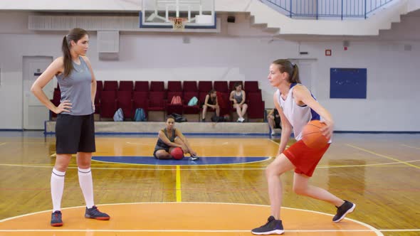Young Female Basketballs Athletes Having Partner Workout on Court