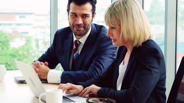 Two Business People Talk Project Strategy at Office