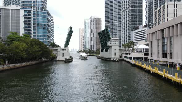 A luxury motor yacht makes its way back to the harbor in the Miami River.  The Brickell Avenue Bridg