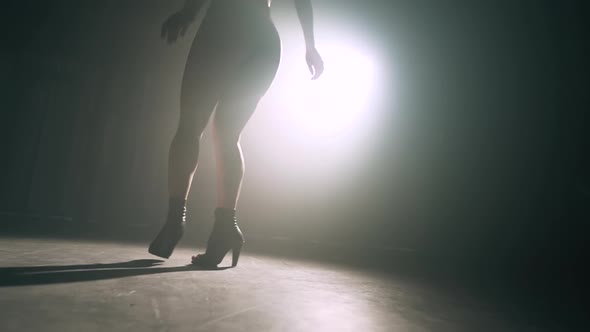 Dancer's Legs in Dark in Smoky Room of Nightclub. Girl Dances Beautifully