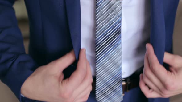 Man Buttoning a Button on His Jacket Closeup