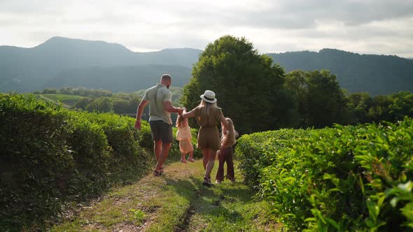 Happy Family of Man Woman and Two Cute Little Daughters Walking in Nature