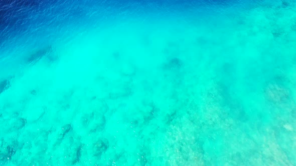 Natural flying tourism shot of a summer white paradise sand beach and blue ocean background 
