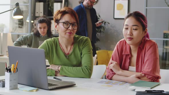 Portrait of Multiethnic Businesswoman and Female Trainee in Office