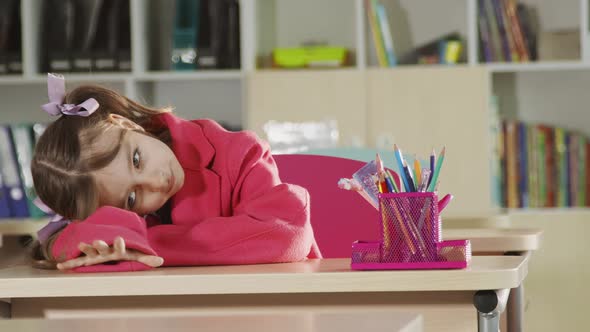 A Child at School Who Sits at a Desk, Misses and Goes To Bed. A Child Who Is Bored at School at the