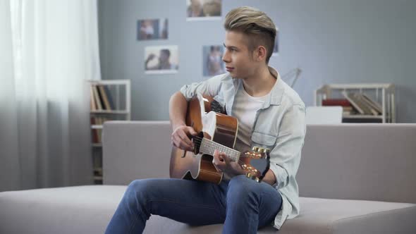 College Guy Enjoying Melody for His New Song, Talented Teenager Playing Guitar