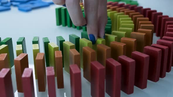 Line up of Dominoes in Rainbow Falling Colors with LGBT Colors of a Hand