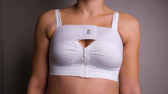 Woman Wearing Support Bra and Compression Band Post Breast Surgery And Turning Slowly To Both Sides.