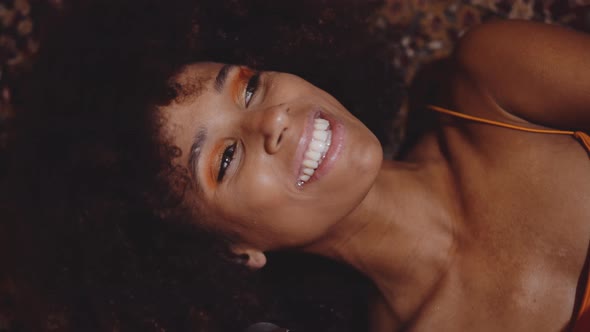 Woman With Afro Hair Lying On Floor With Vintage 8Mm Camera